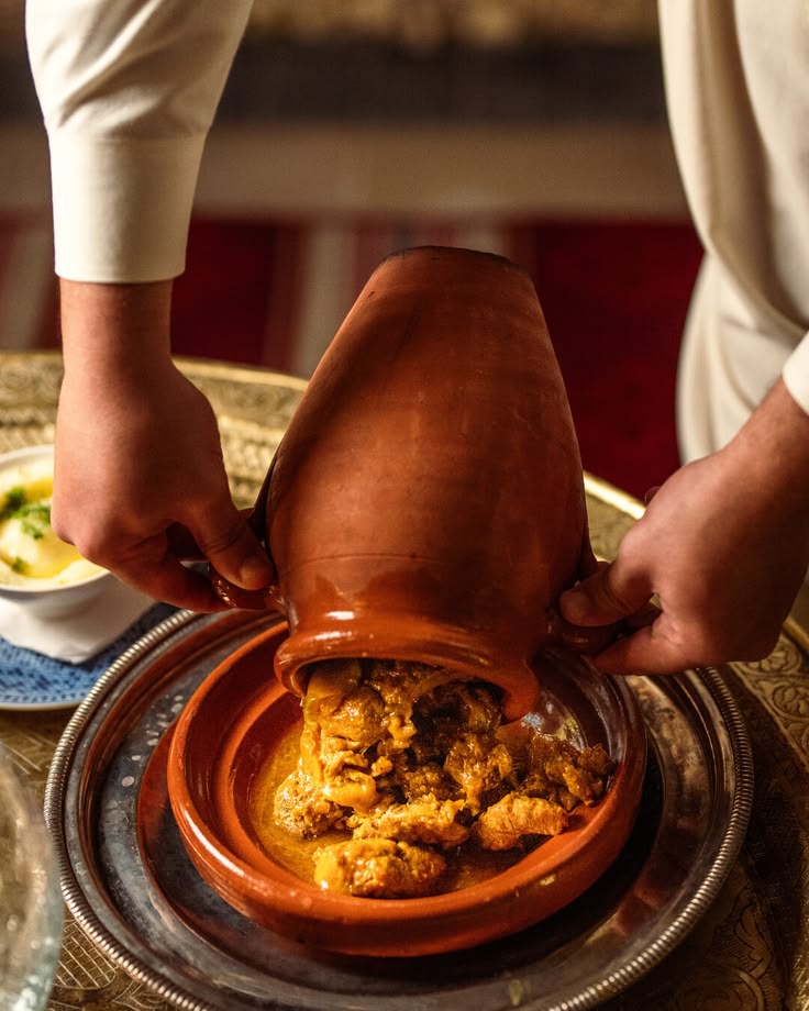 Chef pouring a traditional Moroccan tagine tableside